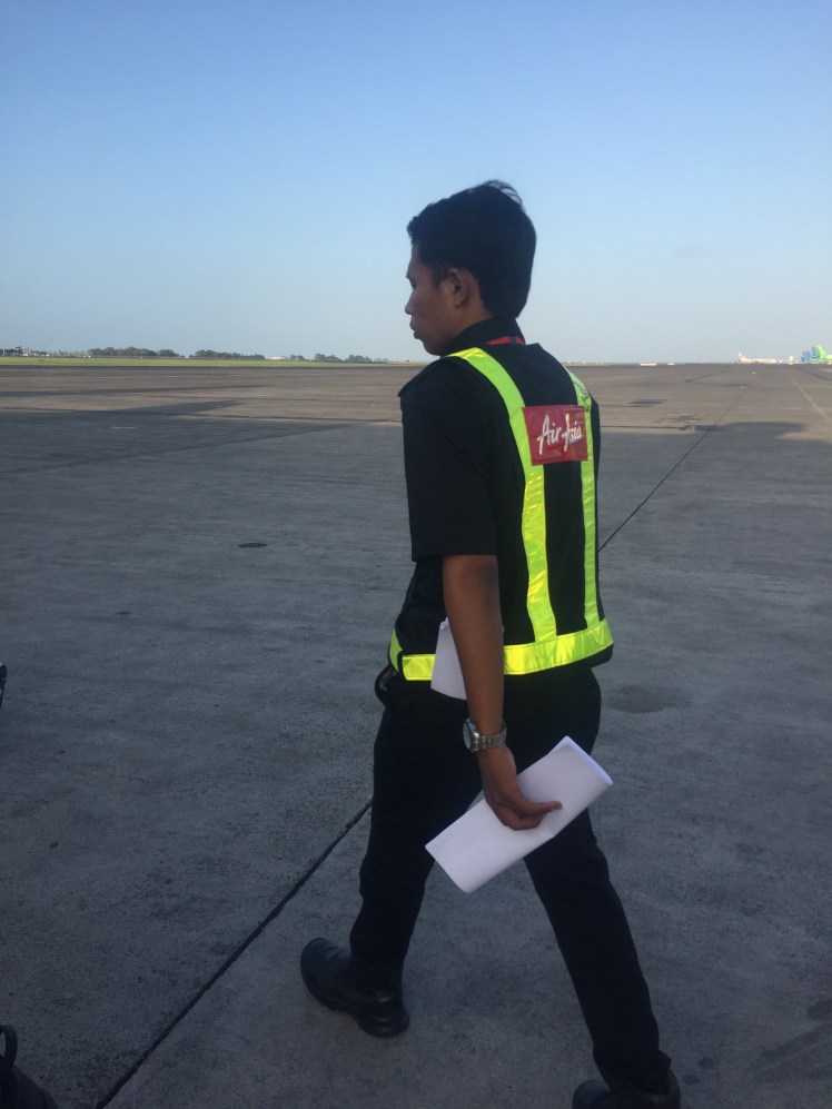 Air Asia staff escort onto plane at Denpasar International Airport in Bali, Indonesia