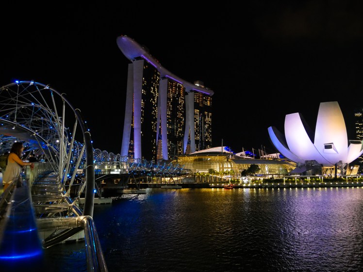 Travel girl on Helix Bridge in Singapore at night