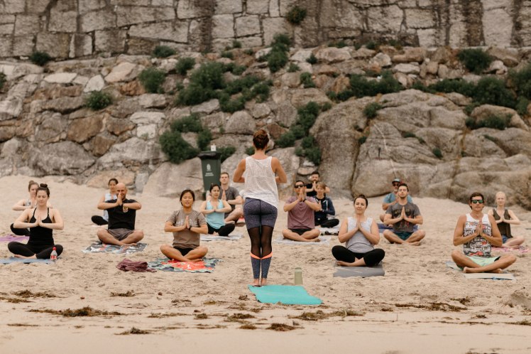 Beach yoga class in sukasana